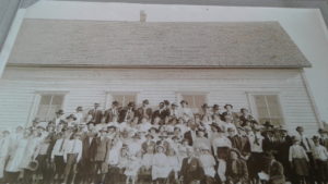 Necessity School. Rankin and Ethel, end of 3rd row of those standing, with big hats.